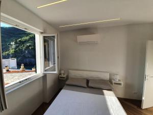 a room with a bed and a large window at Affittacamere Benedetta e Isabelle in Vernazza