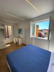 a bedroom with a blue bed and two windows at Affittacamere Benedetta e Isabelle in Vernazza