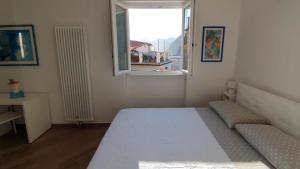 a white bedroom with a bed and a window at Affittacamere Benedetta e Isabelle in Vernazza