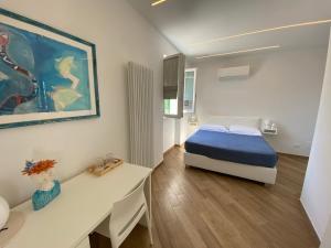 a white bedroom with a bed and a desk and a table at Affittacamere Benedetta e Isabelle in Vernazza