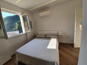 a bedroom with two beds and a large window at Affittacamere Benedetta e Isabelle in Vernazza
