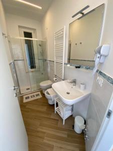 a bathroom with a sink and a toilet and a mirror at Affittacamere Benedetta e Isabelle in Vernazza