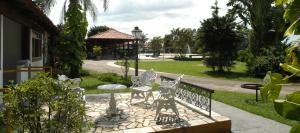 een park met een tafel en stoelen op een patio bij Hotel Fazenda Sete Lagos in Guaratinguetá