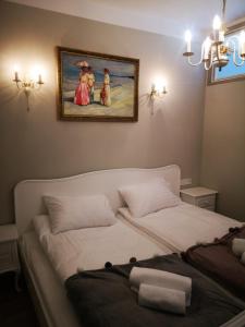 a bedroom with two beds and a painting on the wall at Romantyczny Apartament HAPPY 16 BASEN & KORT TENISOWY, OCHRONA 24 h - dla maksymalnie 6 osób in Pobierowo