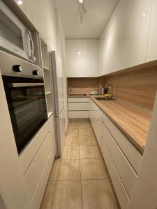 a kitchen with white cabinets and a stove top oven at Bizi Green - Zagreb South in Zagreb
