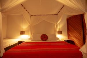 a bedroom with a large bed with a red blanket at Na Villa dos Algodões in Marau