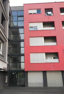 a red building in front of a glass building at Bizi Green - Zagreb South in Zagreb
