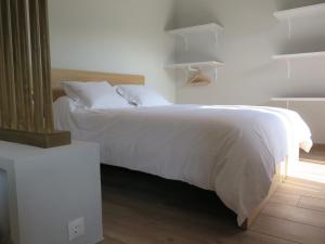a bedroom with a bed with white sheets and pillows at LA CASINA DEL OLIVO in Ribadesella