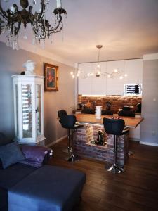 a living room with a couch and a table and chairs at Romantyczny Apartament HAPPY 16 BASEN & KORT TENISOWY, OCHRONA 24 h - dla maksymalnie 6 osób in Pobierowo