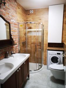 a bathroom with a sink and a shower and a washing machine at Romantyczny Apartament HAPPY 16 BASEN & KORT TENISOWY, OCHRONA 24 h - dla maksymalnie 6 osób in Pobierowo
