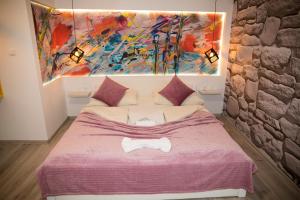 a bedroom with a bed with a painting on the wall at Hotel Villa Nadin in Mostar