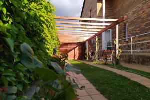 un patio trasero con pérgola de madera y césped en LOS CIERVOS - Peña del Oso en El Espinar