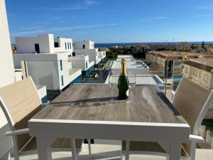 Playa Flamenca - Turquesa del Mar - great sea view! في بلايا فلامنكا: طاولة مع زجاجة من النبيذ على شرفة