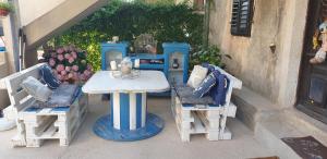 a table and two chairs and a table and a table and chairs at Apartman Opal in Čunski