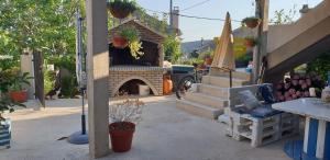 a patio with a fireplace and a table and a chair at Apartman Opal in Čunski +12 photos