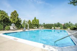 una gran piscina azul con sillas y árboles en Days Inn by Wyndham Westminster en Westminster