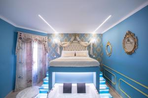 a bedroom with a bed with blue walls at Love Suite Roma - Il Nido d'Amore in Rome