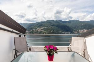 een vaas met bloemen op een tafel op een balkon bij La Terrazza sul Lago di Como con garage in Blevio