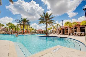 a large swimming pool with palm trees in a resort at 5532 Misty Oak Circle in Davenport