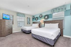 a bedroom with two beds and a flat screen tv at Stylish Home wPrivate Pool&Spa, near Disney in Davenport +81 photos