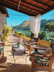 a patio with chairs and a view of the water at Pousada Costa dos Corais in Mangaratiba