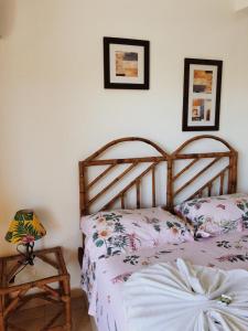 a bedroom with two beds and a table with a lamp at Pousada Costa dos Corais in Mangaratiba