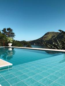 een zwembad met uitzicht op het water bij Pousada Costa dos Corais in Mangaratiba