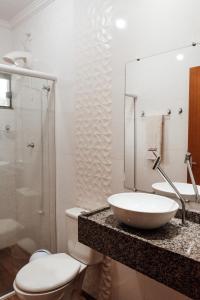 uma casa de banho com um lavatório, um WC e um espelho. em Hotel Engenho em Penha