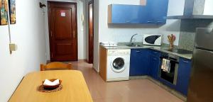 a kitchen with a table and a washing machine at Apartamento Loft II Select Real Caldas de Reis in Caldas de Reis