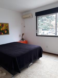 a bedroom with a black bed and a window at Residencial Morada do Sol in Santa Maria +10 photos