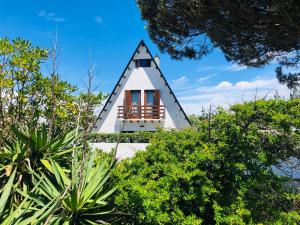 uma casa triangular com uma janela no topo de alguns arbustos em Beachliving Cabana em Esmoriz