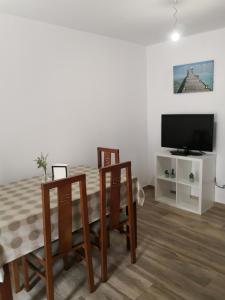 sala de estar con mesa, sillas y TV en Apartamento en casa Portonovo vacaciones, en Portonovo