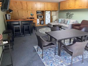 Kin House Guest Suite في أواخورست: غرفة معيشة مع طاولة وكراسي