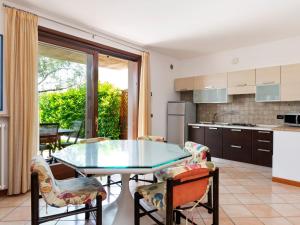 バルドリーノにあるBelvilla by OYO Bardolino Trentanoveのガラスのテーブルと椅子付きのキッチン
