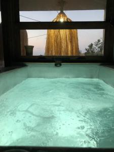 d'une baignoire avec fenêtre et vue sur la douche. dans l'établissement Istron Breeze Isla, à Istron