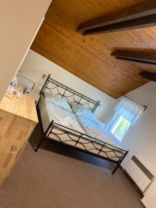 un letto a soppalco in una camera con soffitto in legno di Penzion & Restaurace U Vily a Sezimovo Ústí
