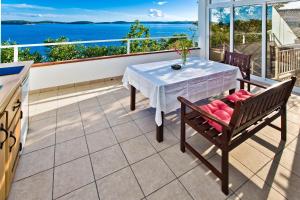 a balcony with a table and chairs and the ocean at Apartments Villa Marcelina in Hvar