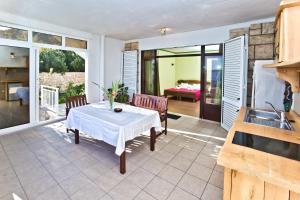 eine Terrasse mit einem Tisch und Stühlen sowie ein Schlafzimmer in der Unterkunft Apartments Villa Marcelina in Hvar
