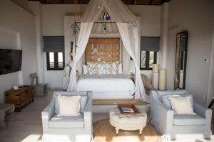 a bedroom with a bed and two chairs at Esperanza, Auberge Resorts Collection in Cabo San Lucas