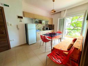 a kitchen with a table and chairs and a refrigerator at COZY & COOL Apartment N2 30m from sea in Nea Kalikratia