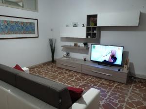 a living room with a couch and a flat screen tv at Chiara Naxos Apartment in Giardini Naxos