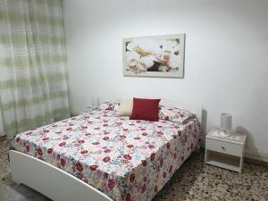 a bedroom with a bed with a floral bedspread at Chiara Naxos Apartment in Giardini Naxos
