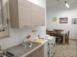 a kitchen with a sink and a table at Chiara Naxos Apartment in Giardini Naxos