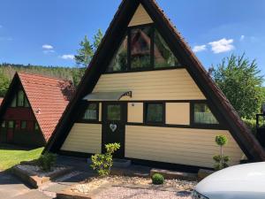 una casa con techo de gambrel con garaje en Gemütliches Ferienhaus in ruhiger Lage Ronshausen Hessen en Ronshausen