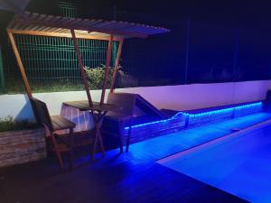 una piscina con una mesa y una silla por la noche en Villa Mango en Le Gosier