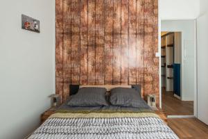 a bedroom with a bed with a wooden wall at L'urbain Narbonnais in Narbonne