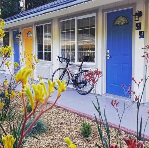 una bicicleta estacionada fuera de una casa con una puerta azul en Casa Secoya en Monte Rio