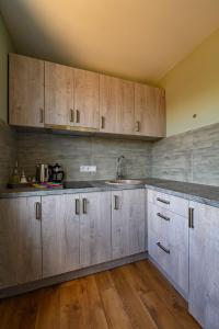 een keuken met houten kasten en een spoelbak bij Beachside Oak Studio in Liepāja +35 foto's