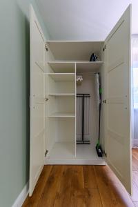 een kast met witte deuren en een houten vloer bij Beachside Oak Studio in Liepāja