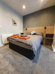 a bedroom with a large bed with orange pillows on it at City Space in Doncaster